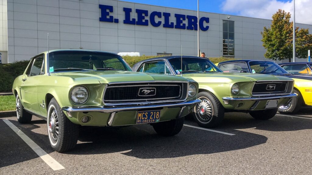 Two identical 1968 Mustang Survivors parked side by side in France.