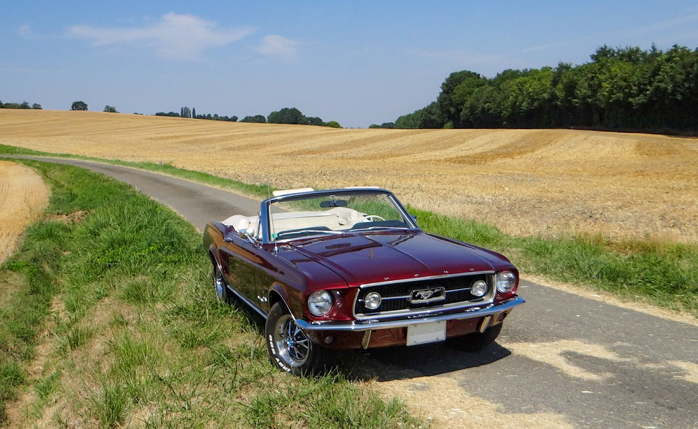 1967 Mustang Convertible Vintage Burgundy parked by the roadside with cream interior visible, classic American convertible styling