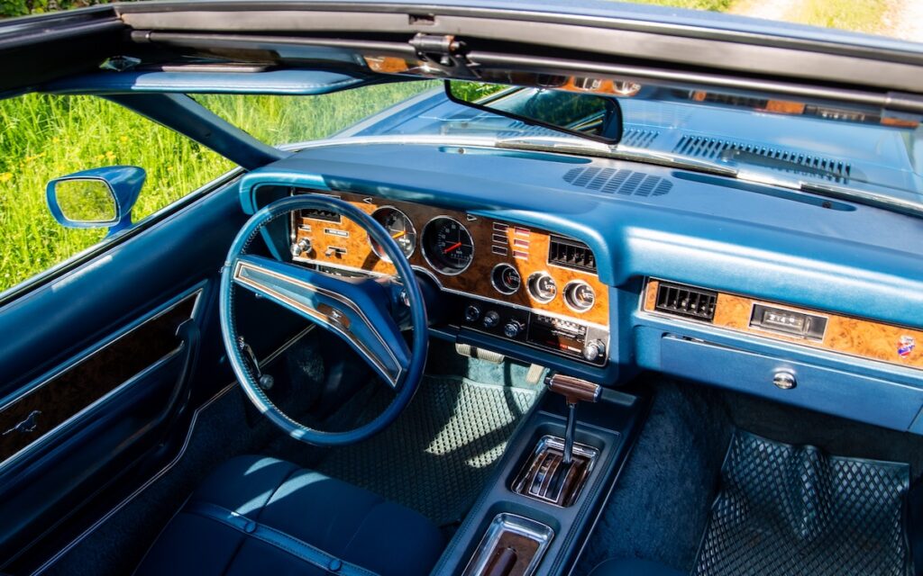Woodgrain dashboard and blue interior of a 1974 Mustang II Ghia