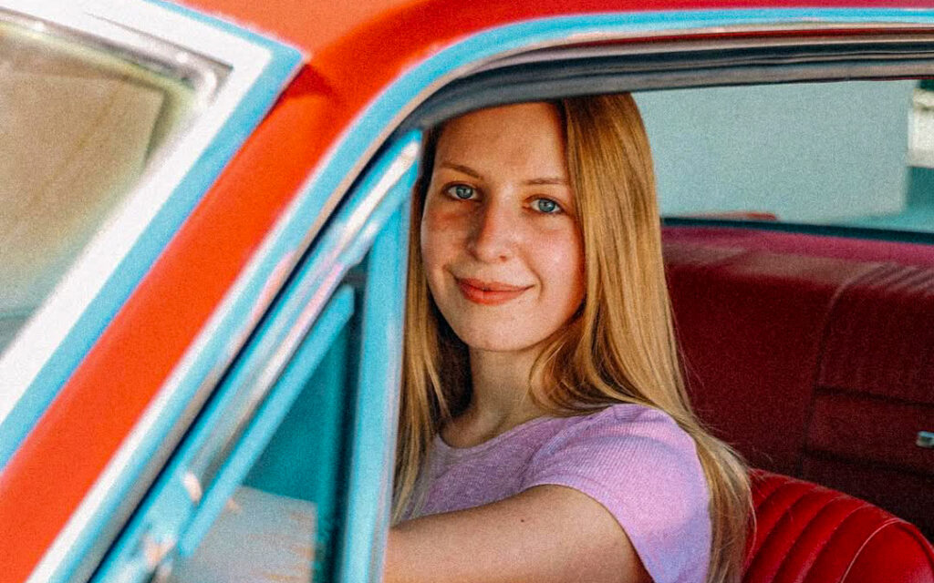 Close-up of Francesca behind the wheel of her 1966 Ford Mustang