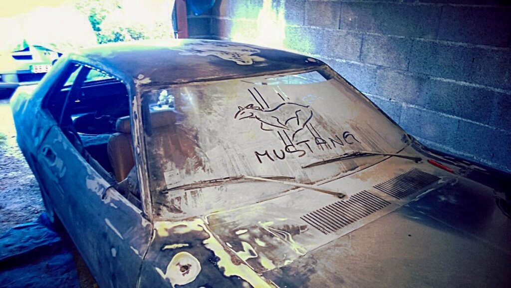 1978 Ford Mustang II Hardtop bodywork during restoration, sanding phase with dust and Mustang logo