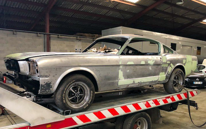 Stripped down to bare metal: the fastback reveals decades of past repairs before deeper bodywork can begin.