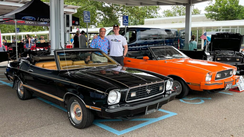 Robert standing with Mike, former Ford executive, next to two rare Mustang II Classic II convertibles.
