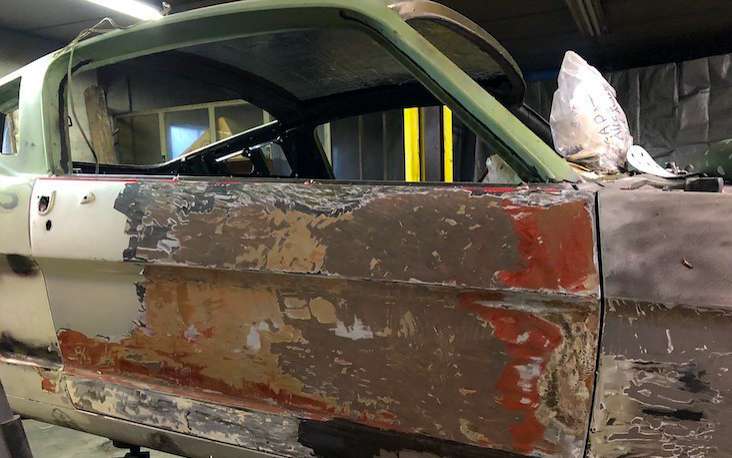 A glimpse into the car’s past: layers of Bronze, red, and other colors appear on the passenger door, evidence of multiple resprays over the years.