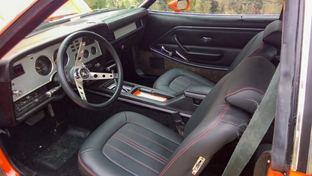 1978 Ford Mustang II restored interior with black leather seats and orange stitching