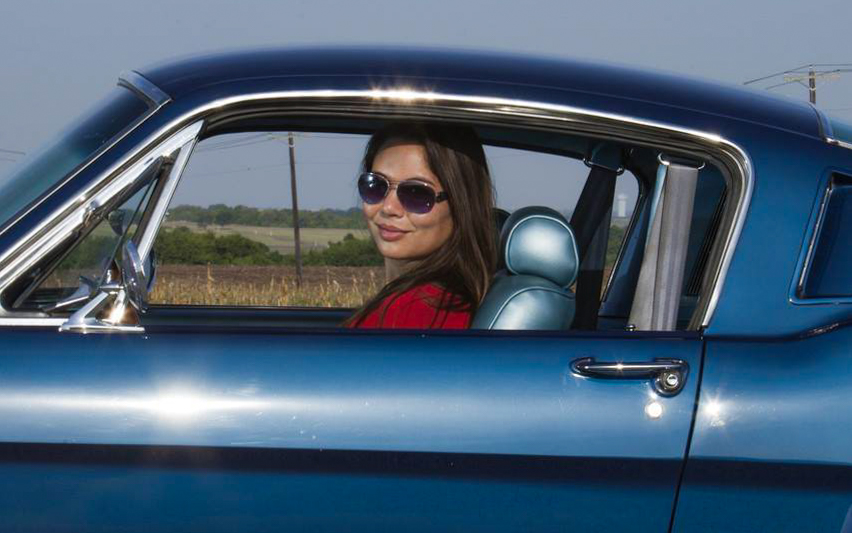 Kelly behind the wheel of her 1966 Mustang Fastback.