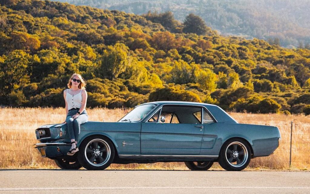 Marissa sitting on the front fender of her Mustang.