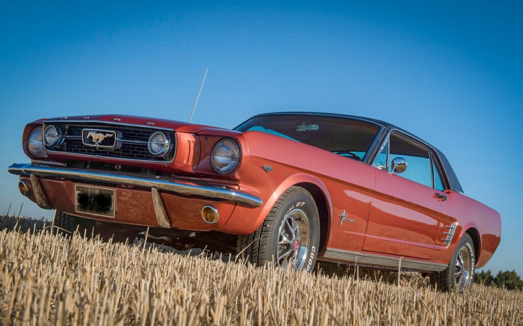 1966 Mustang Emberglo in a wheat field after restoration