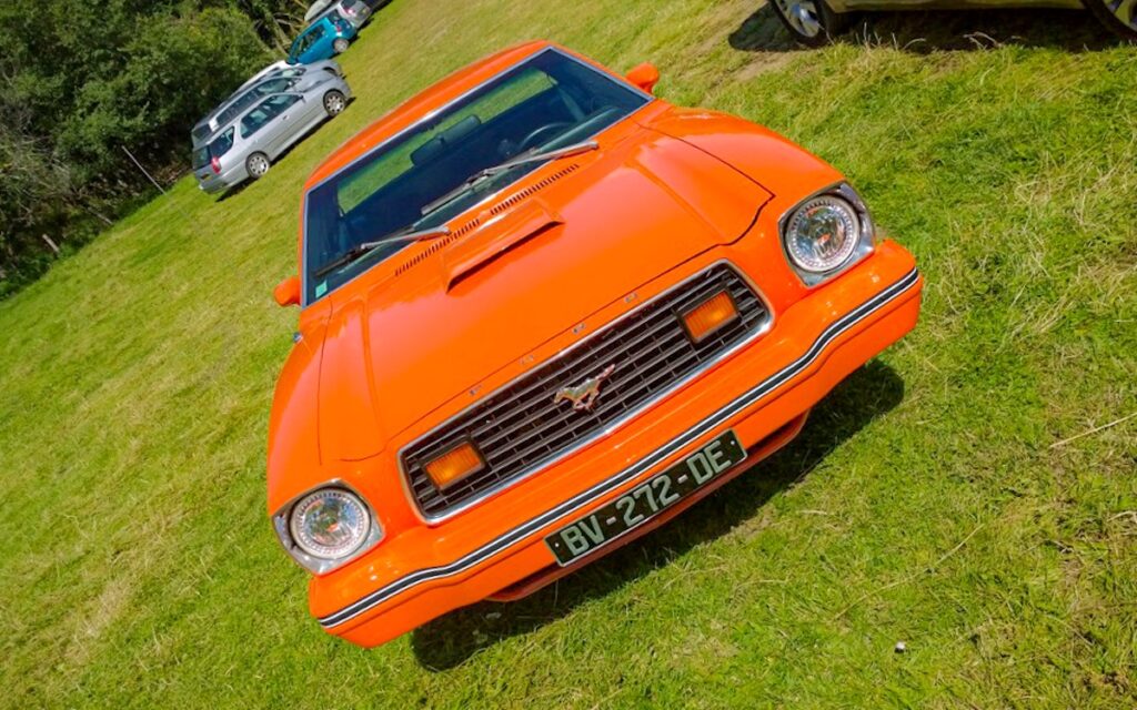 1978 Ford Mustang II Hardtop restored in Tangerine Orange parked in the mountains during family road trip