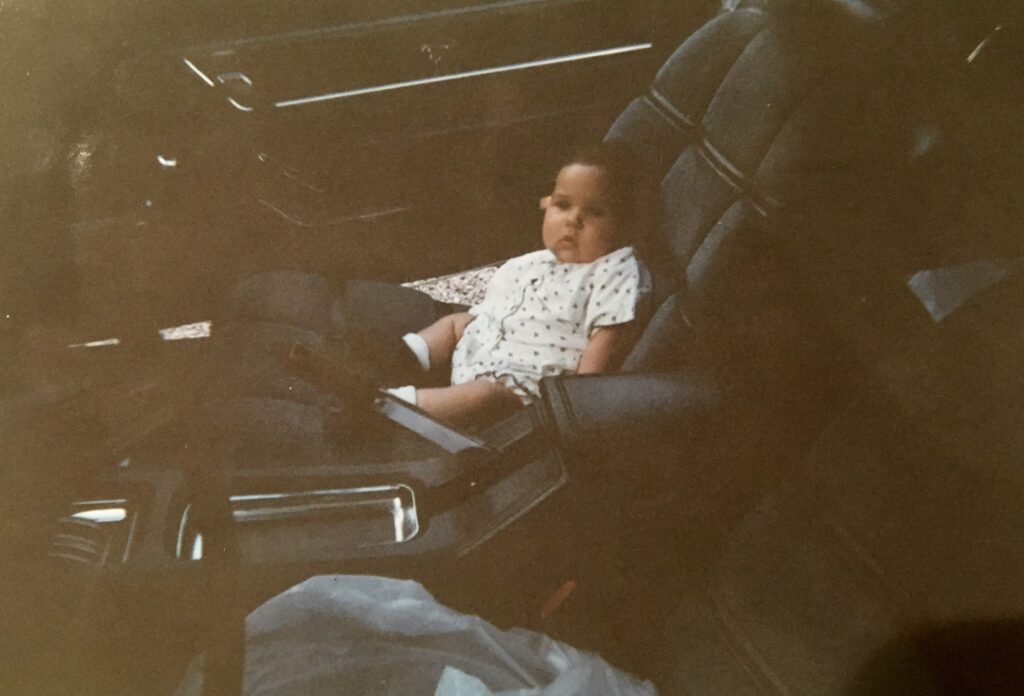 Jade as a baby sitting in the passenger seat of her father’s 1976 Mustang II Ghia.