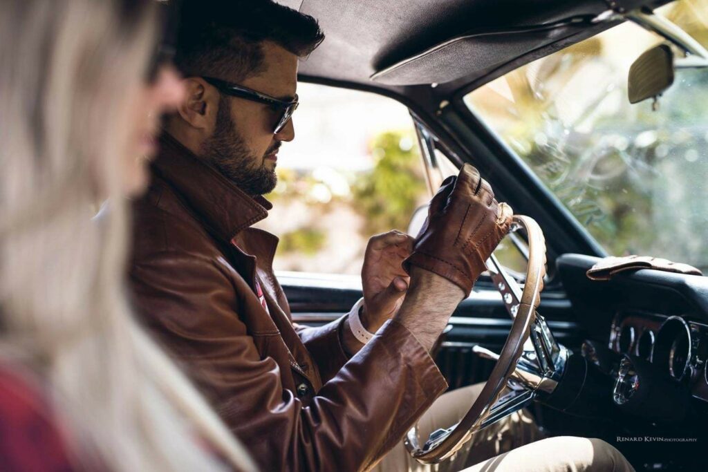 A quiet moment before the drive—Sébastien slipping on his driving gloves behind the wheel of his ’66 Mustang.