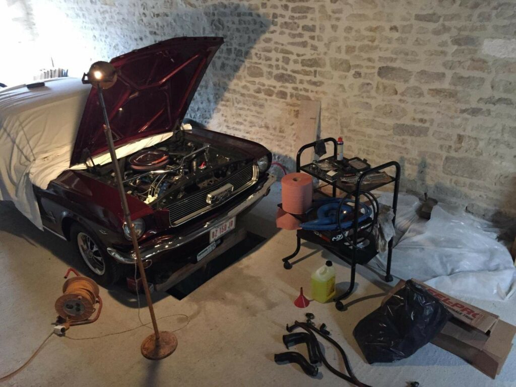 Kelly in Sébastien’s workshop—a former barn transformed into a personal garage, complete with tools and a pit for hands-on work.