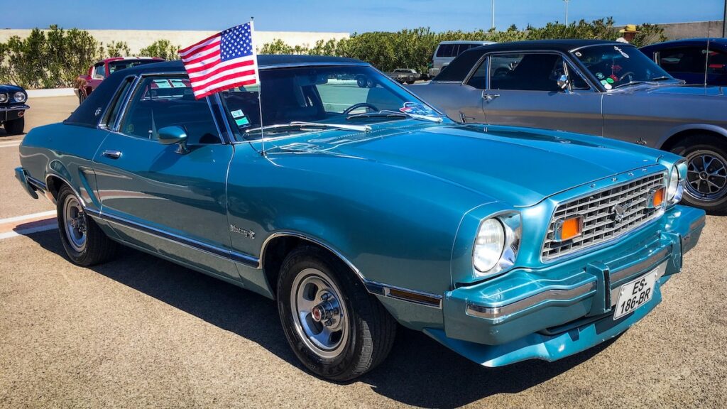 1976 Mustang II Ghia with an American flag on the antenna, a classic US car preserved by the same family.