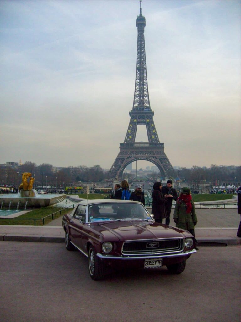 1968 Ford Mustang convertible parked in front of the Eiffel Tower in Paris