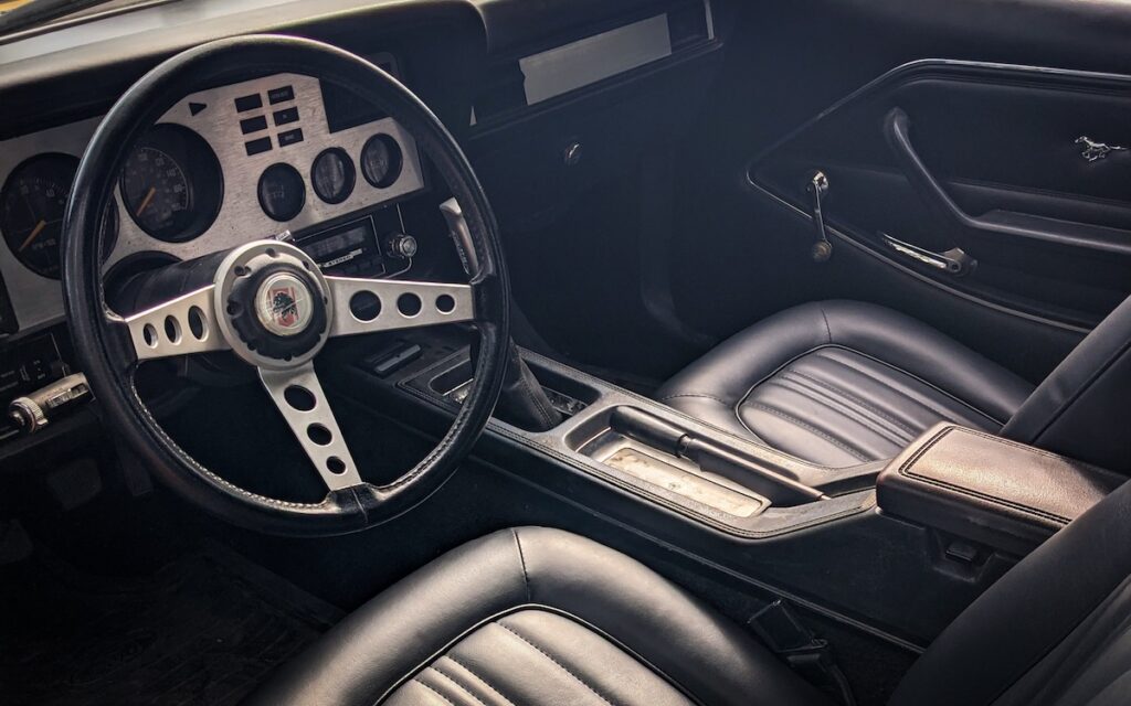 Interior of a Mustang II Cobra II with black trim and aluminum dashboard