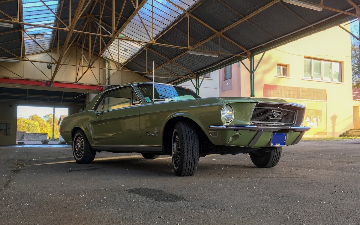 1968 Mustang Survivor parked in front of a photogenic building, front low-angle view