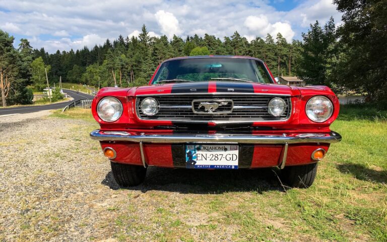 Chloe’s restored 1966 Ford Mustang driving on a quiet road in Auvergne, France.