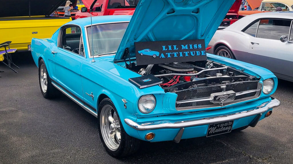Displayed with its hood open at a car show, the Mustang proudly wears its nickname: "Lil Miss Attitude." Photo credit: Johnny Kovalick
