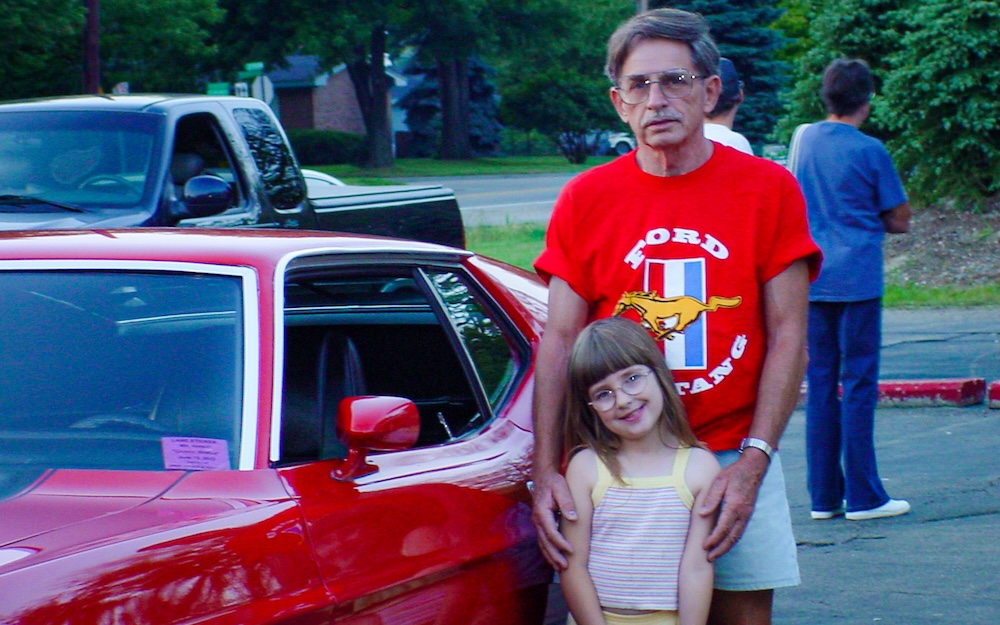Heather as a child with her grandfather Frank and their Mustang at Dairy Queen in 2002