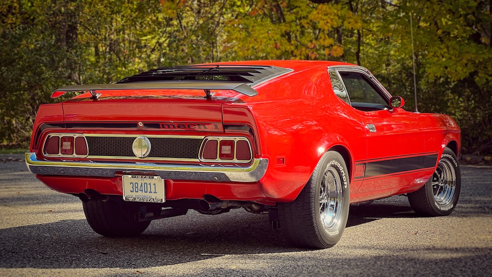 Rear view of Heather's red 1973 Mustang Mach 1 in 2023